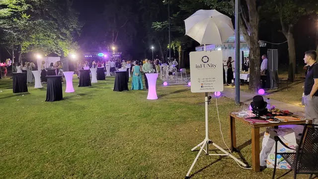 Invitați, lumini de petrecere și cabina foto inFUNity într-un decor exterior nocturn