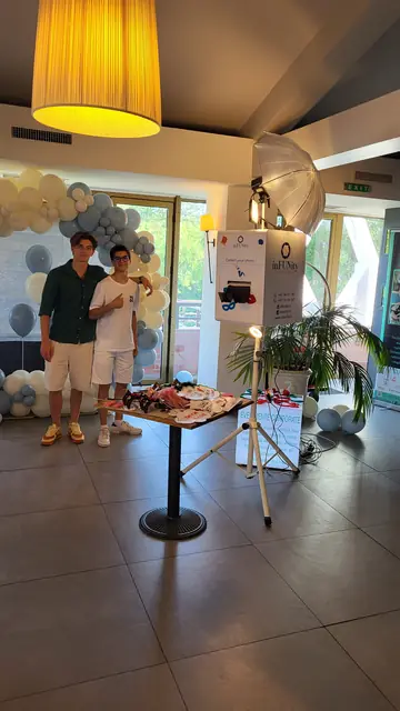 Invitați lângă cabina foto inFUNity, într-o sală cu arcadă decorată cu baloane